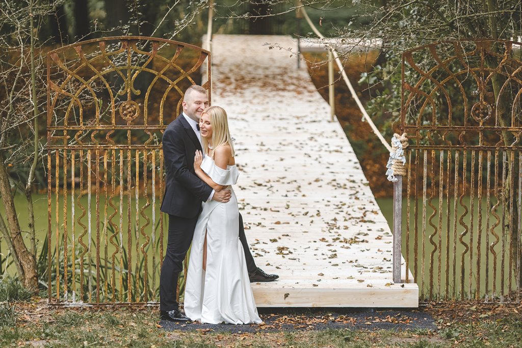 spacer w pięknym ogrodzie pary młodej, zieleń i metalowe dekoracje ślubne