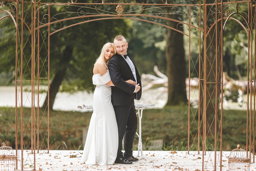 spacer w pięknym ogrodzie pary młodej, zieleń i metalowe dekoracje ślubne