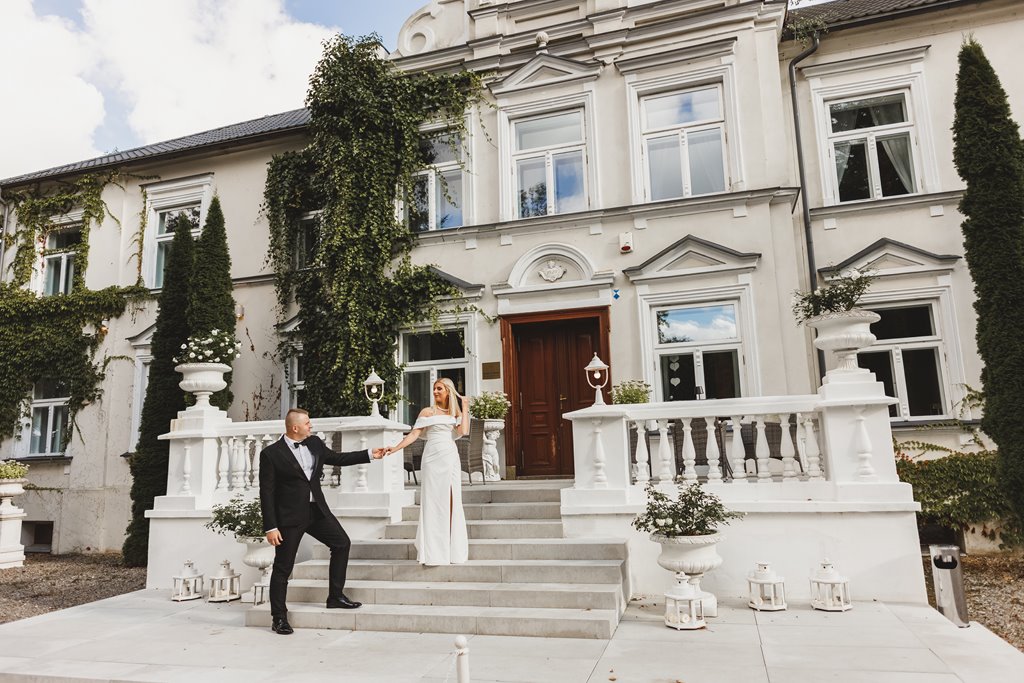 spacer w pięknym ogrodzie pary młodej, zieleń i metalowe dekoracje ślubne pałac weselny