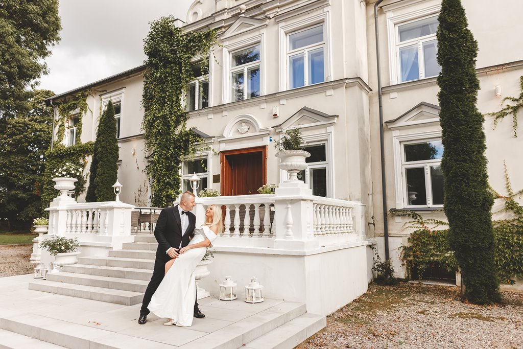 spacer w pięknym ogrodzie pary młodej, zieleń i metalowe dekoracje ślubne pałac weselny