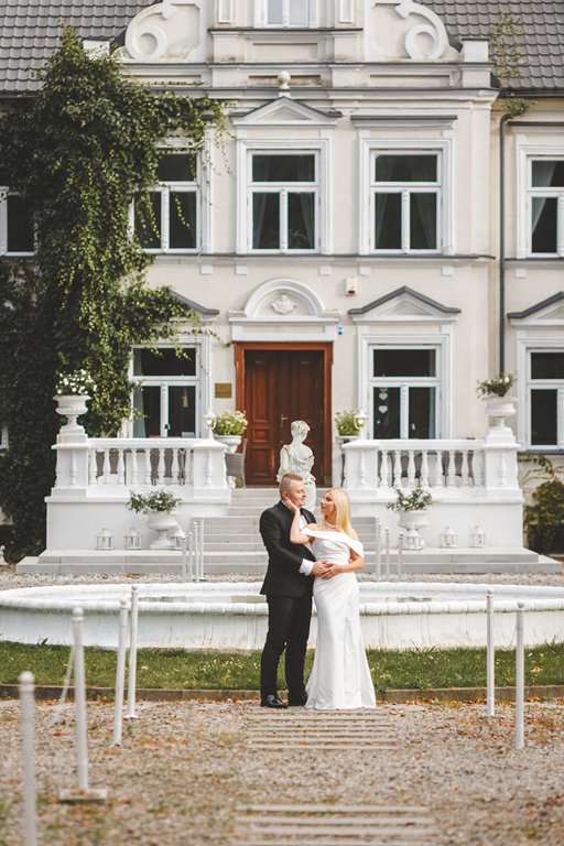 spacer w pięknym ogrodzie pary młodej, zieleń i metalowe dekoracje ślubne pałac weselny