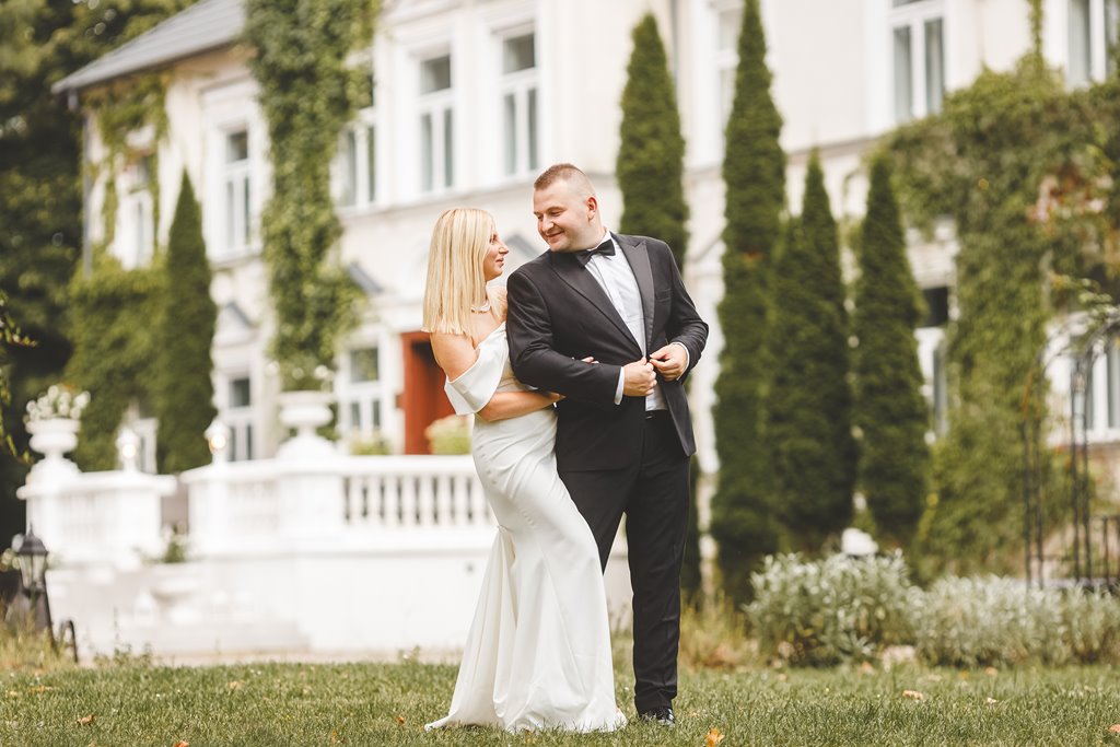 spacer w pięknym ogrodzie pary młodej, zieleń i metalowe dekoracje ślubne