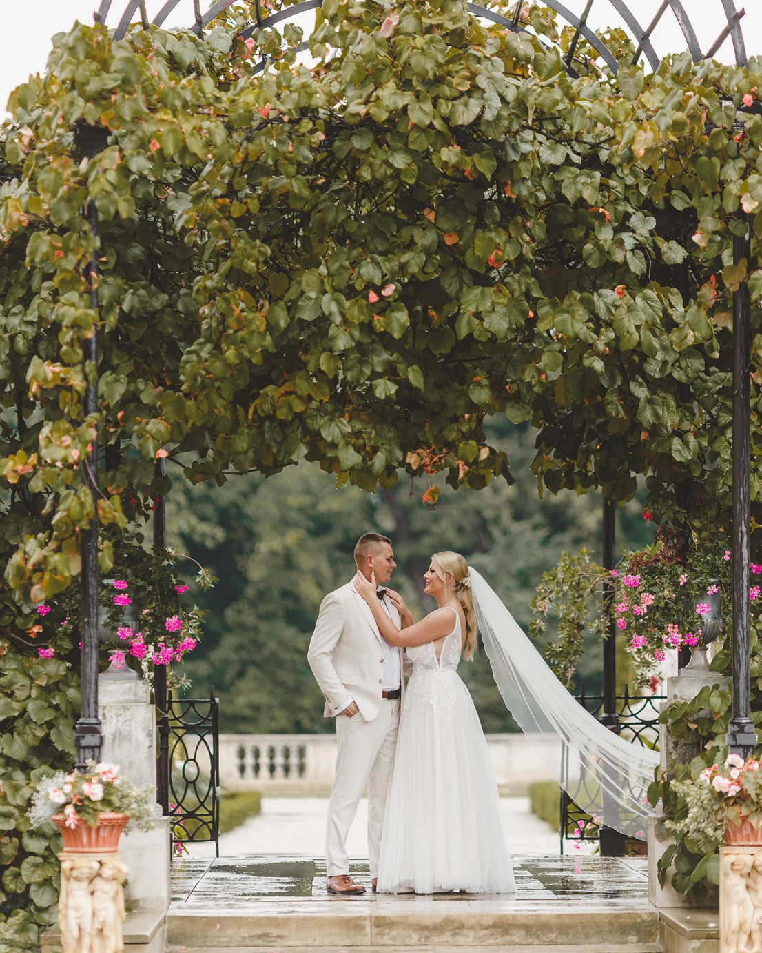 młodzi elegancko ubrani w otoczeniu zieleni uśmiechają się
